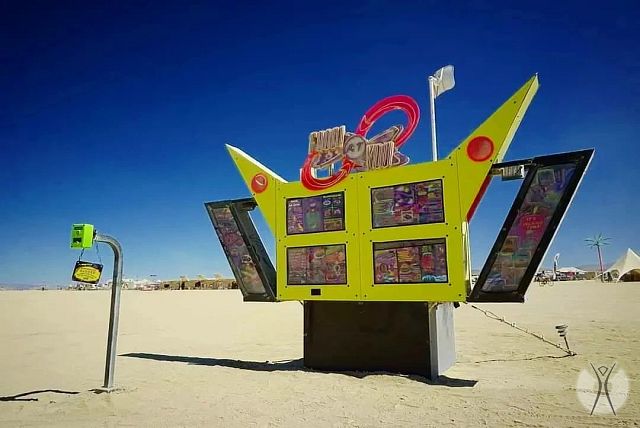 The meme is a photo of a "Lost and Found" board at Burning Man, a popular annual festival in the Nevada desert. The board is shaped like a giant bird, with its wings spread wide, and has a humorous message: "Lost: 1 brain. If found, please return to owner. Reward: endless supply of snacks."